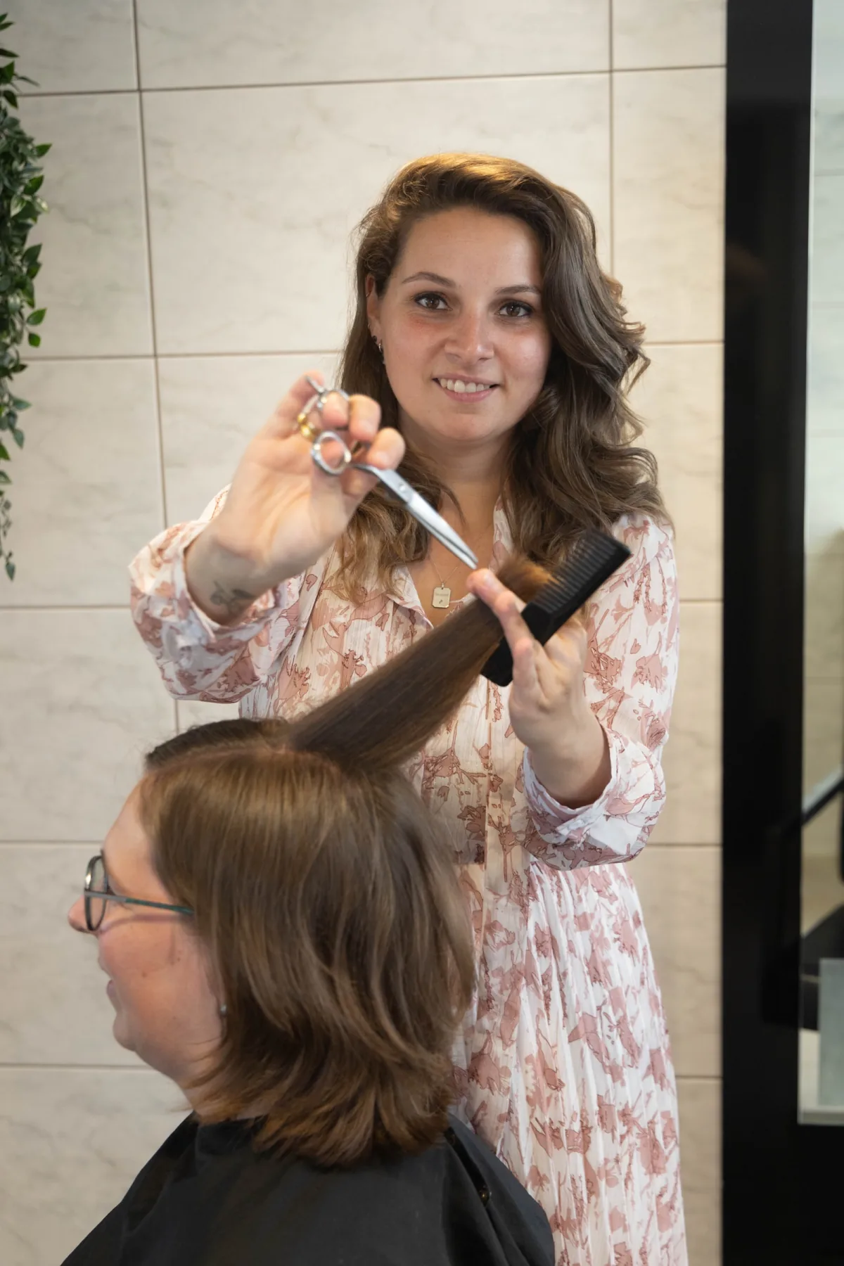 Beau knipt geconcentreerd het haar van een klant